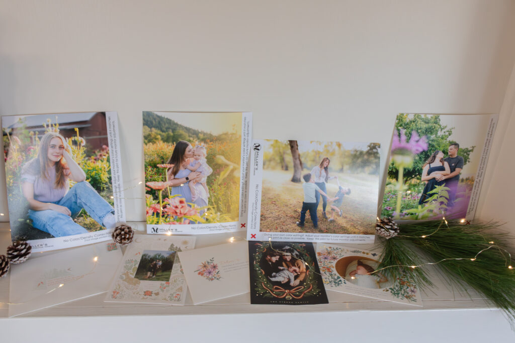Indoor Roseburg Christmas minis photo display with printed family portraits, pine greenery, and twinkle lights.