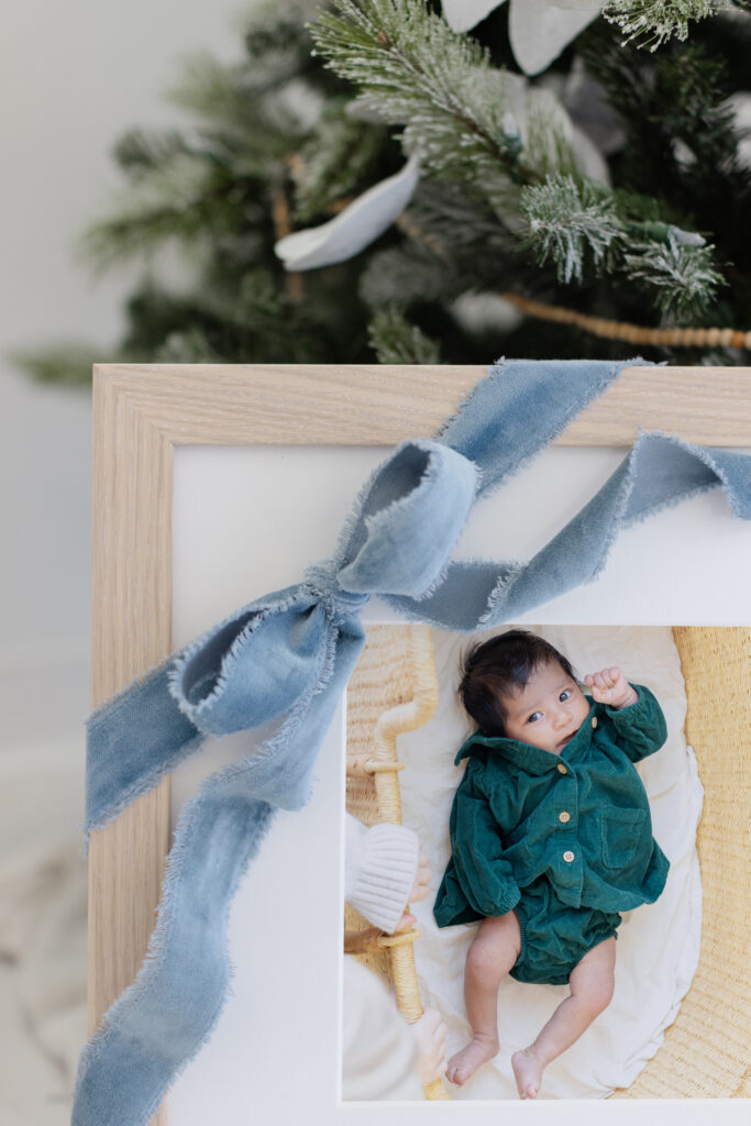 Baby photographed during a Roseburg Oregon Christmas mini session, wearing a green outfit and presented as a framed heirloom holiday portrait in studio