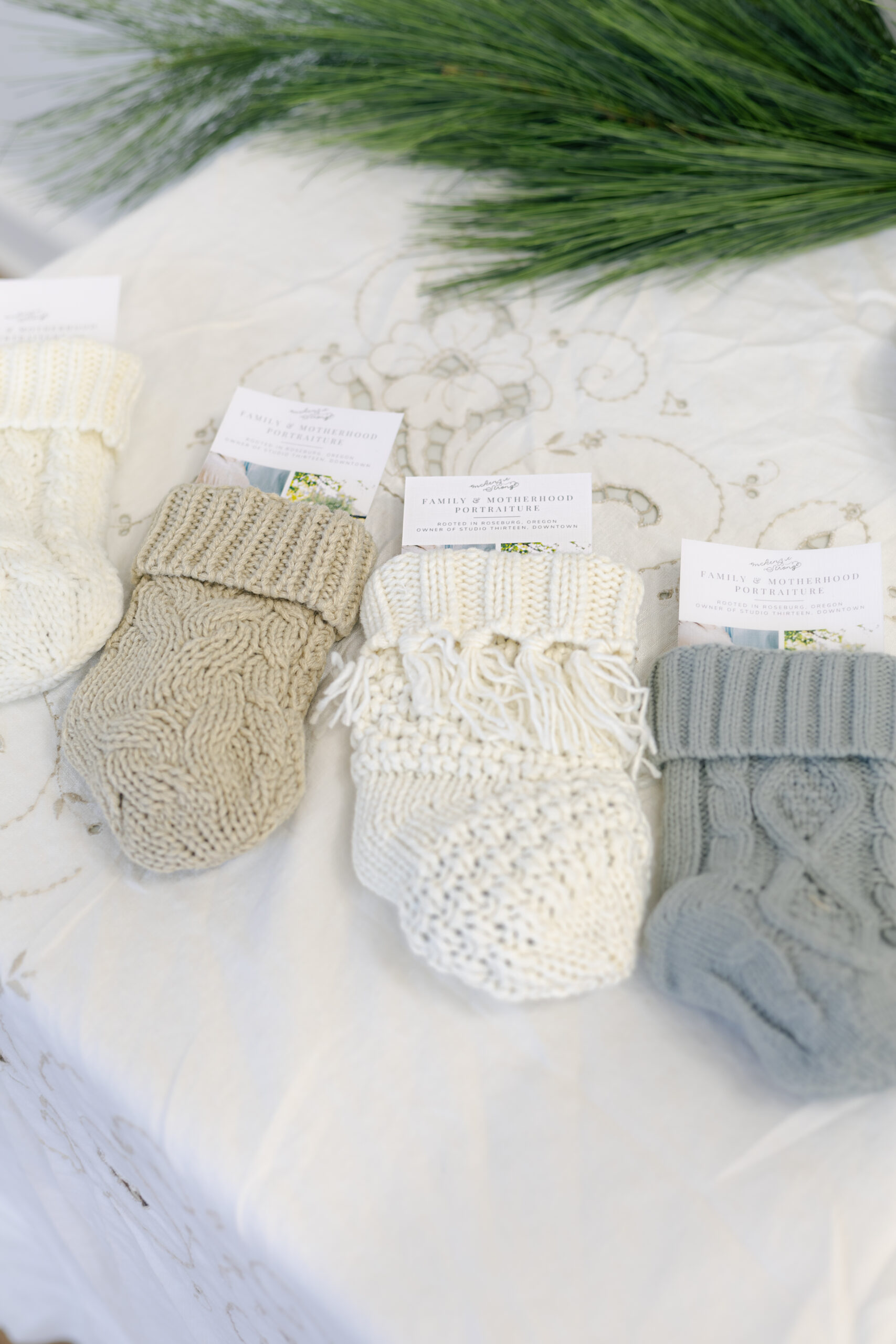 Hand-knit baby stockings given as a client gift during Roseburg Oregon Christmas mini sessions, filled with $10 SOCO Coffee Gift Card, Meadowland Syrup Samples, and Jacobsen Salt Co Caramels.